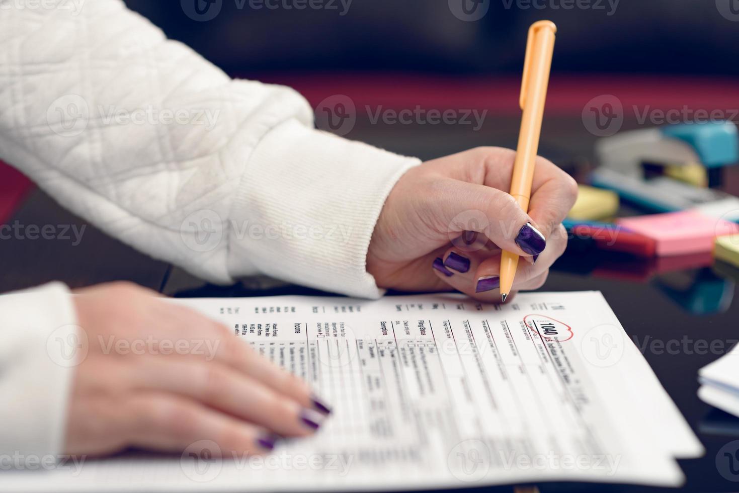 Woman fills the tax form, working with tax documents. Form 1040 Individual Income Tax return form. United States Tax forms. American blank tax forms. Tax time. photo