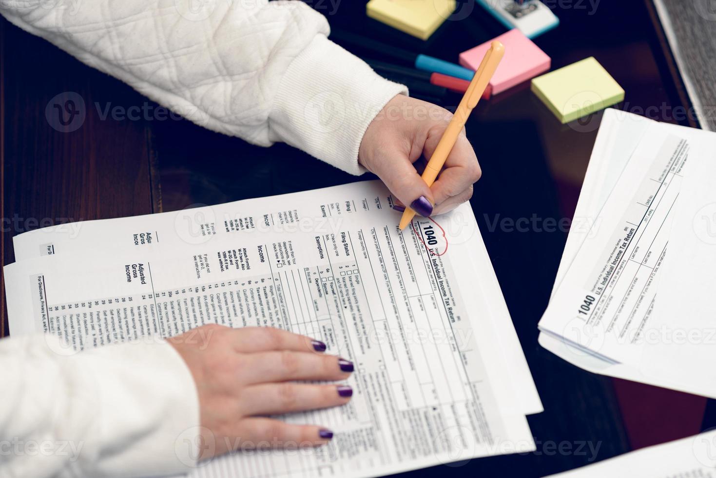 Woman fills the tax form, working with tax documents. Form 1040 Individual Income Tax return form. United States Tax forms. American blank tax forms. Tax time. photo