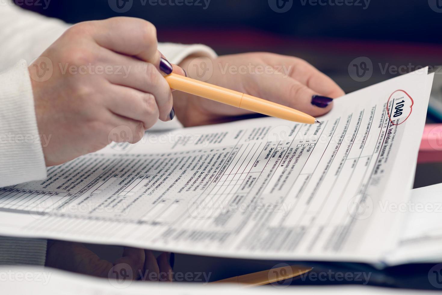 Woman fills the tax form, working with tax documents. Form 1040 Individual Income Tax return form. United States Tax forms. American blank tax forms. Tax time. photo