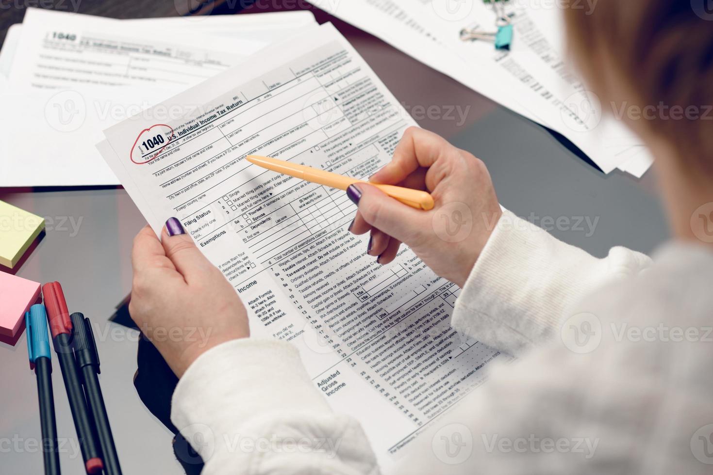 Woman fills the tax form, working with tax documents. Form 1040 Individual Income Tax return form. United States Tax forms. American blank tax forms. Tax time. photo