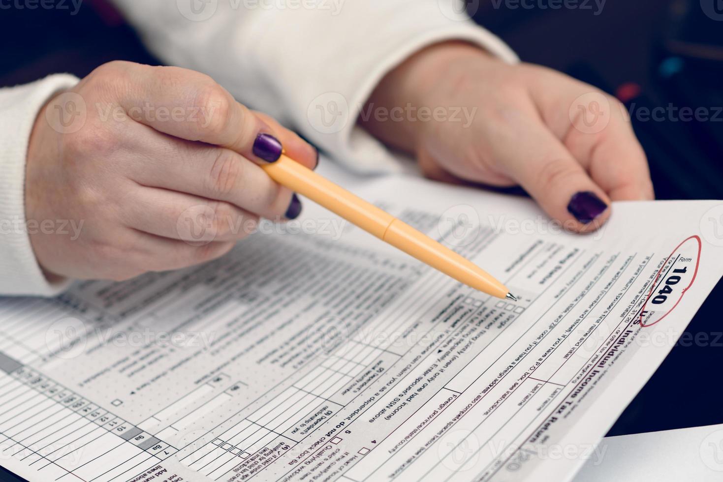 Woman fills the tax form, working with tax documents. Form 1040 Individual Income Tax return form. United States Tax forms. American blank tax forms. Tax time. photo