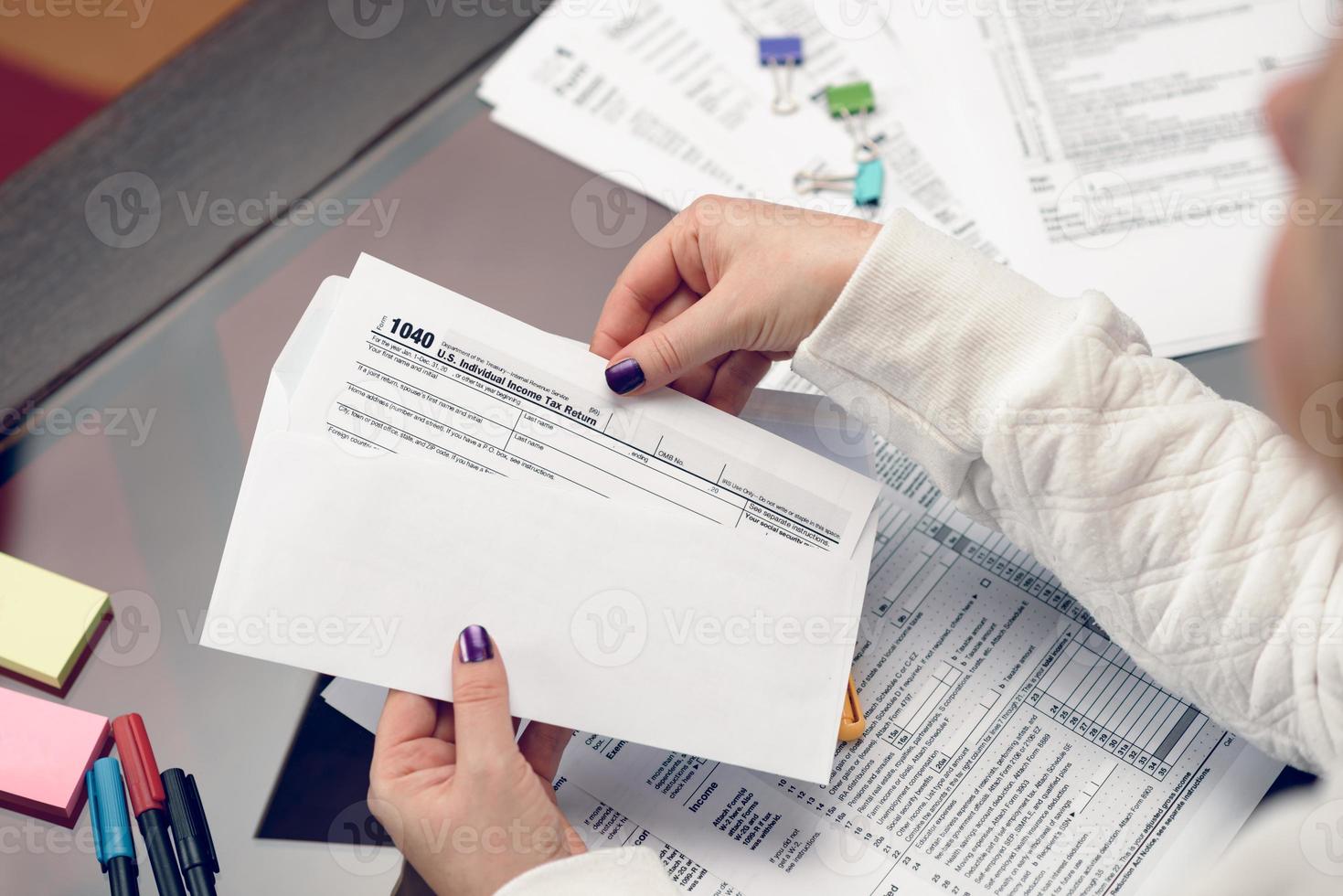 Woman fills the tax form, working with tax documents. Form 1040 Individual Income Tax return form. United States Tax forms. American blank tax forms. Tax time. photo