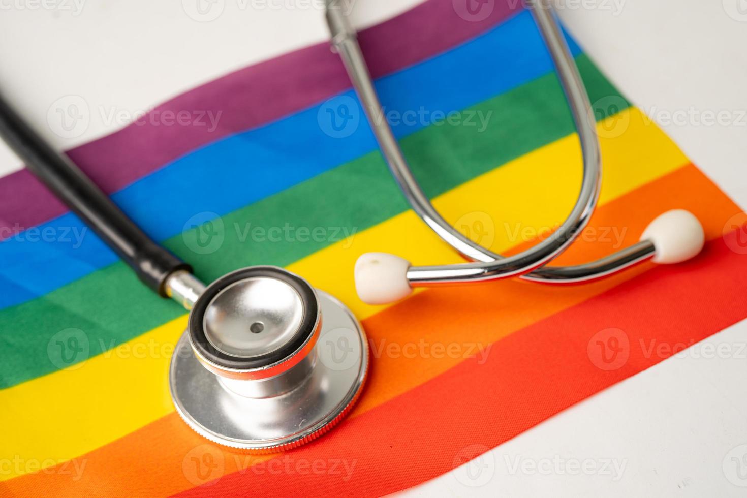 estetoscopio negro sobre fondo de bandera del arco iris, símbolo del mes del orgullo lgbt celebra anualmente en junio social, símbolo de gays, lesbianas, bisexuales, transgénero, derechos humanos y paz. foto