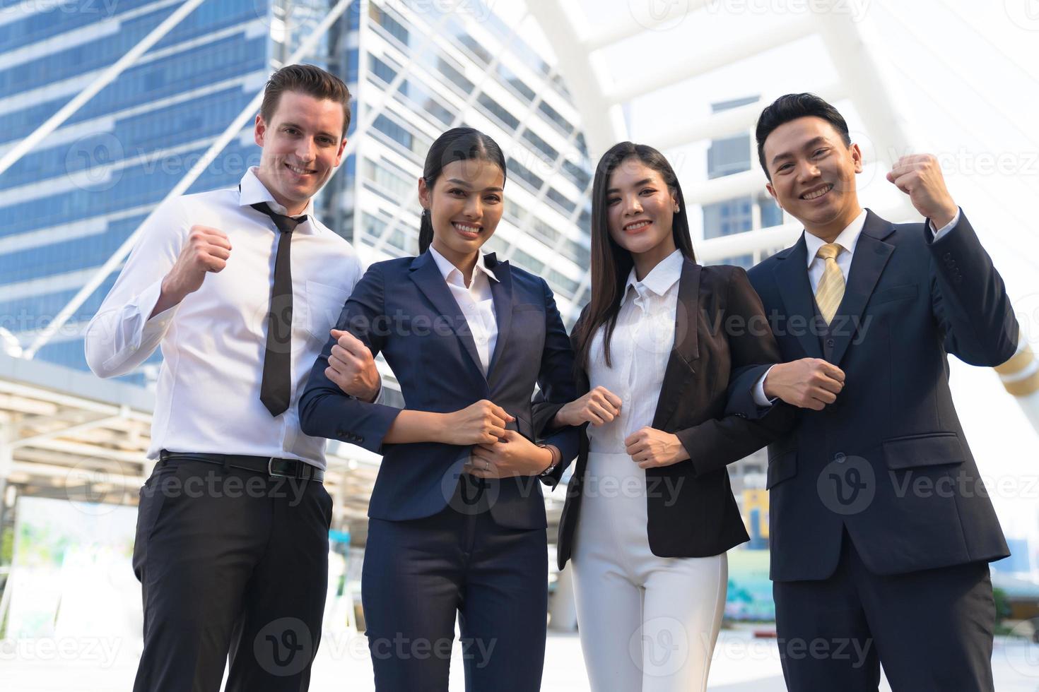Four executives in a row, Business team standing and cheering in front of modern office, Leadership Concept photo