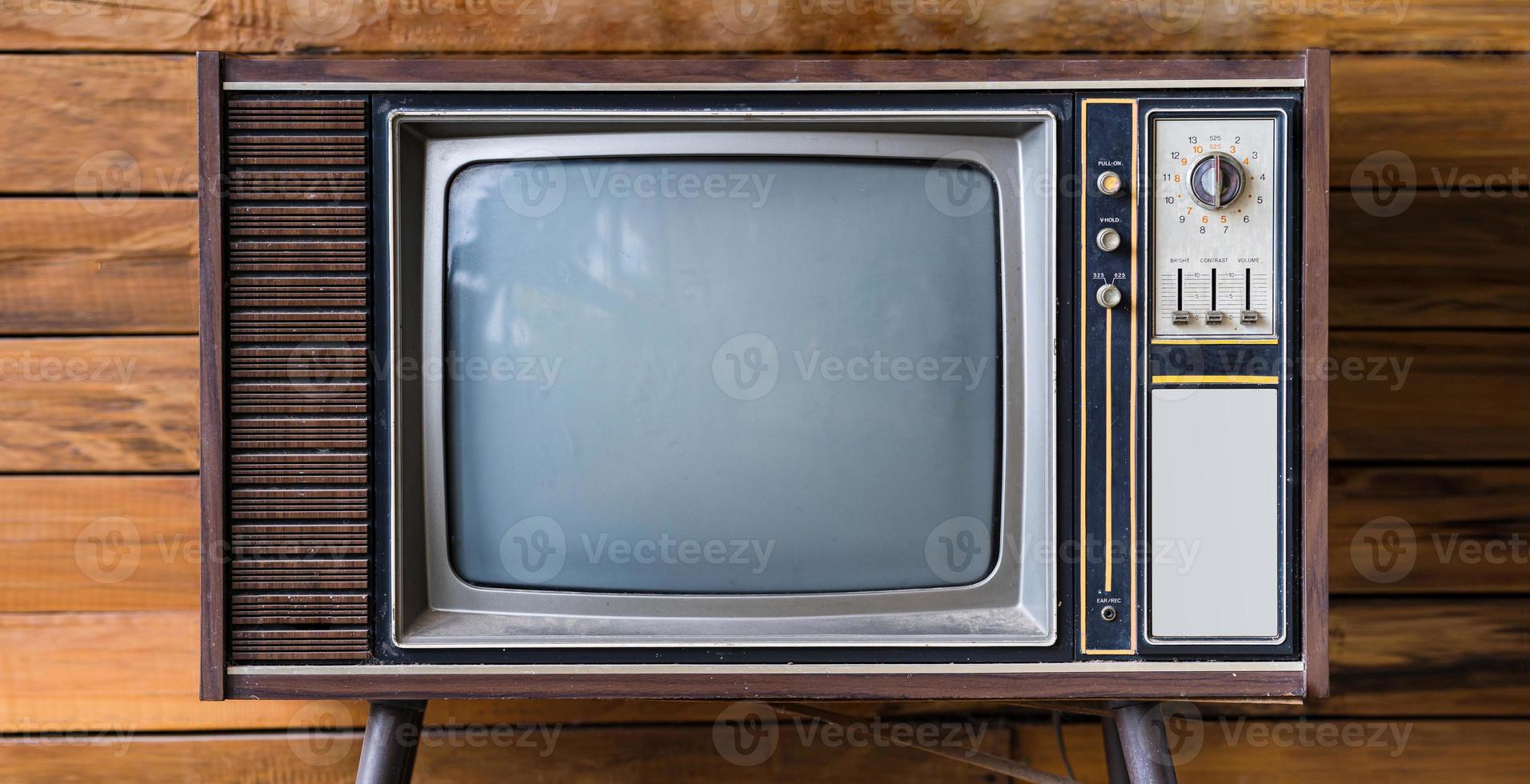 Old tv on wood table in room photo