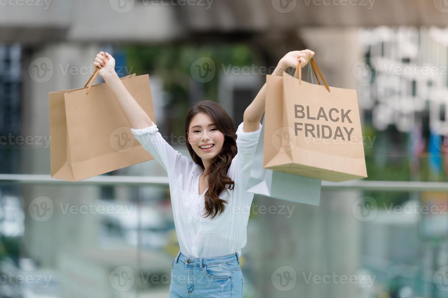 concepto de viernes negro, mujer sosteniendo muchas bolsas de la compra y sonriendo foto