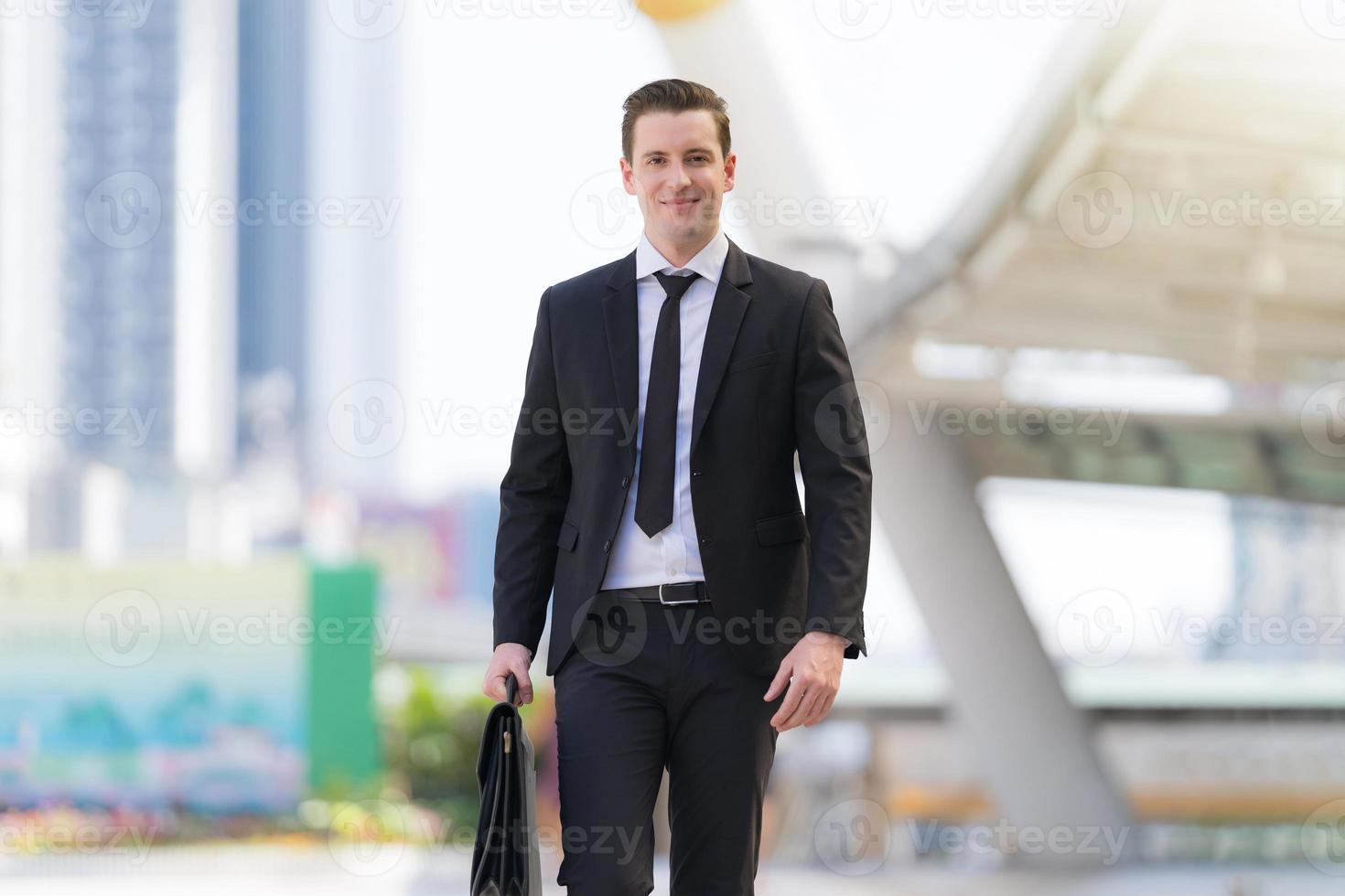 Successful businessman going on business meeting holding briefcase photo