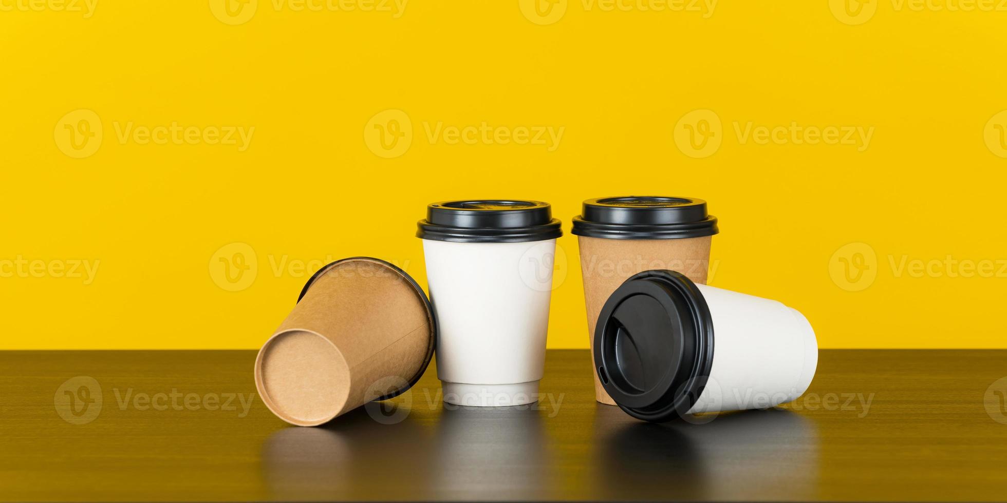 Taza de café de papel en blanco sobre fondo amarillo foto