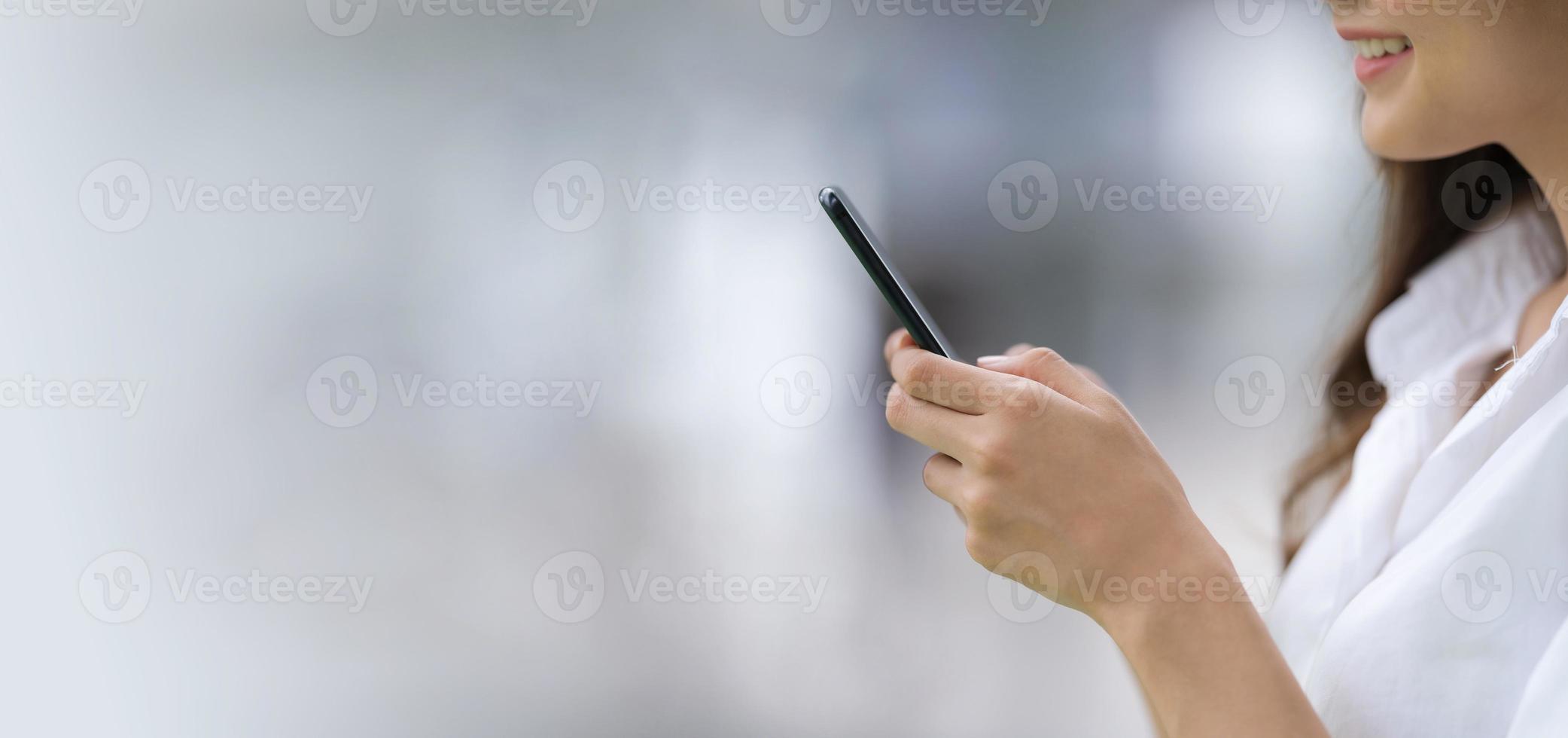 retrato al aire libre de mujer joven feliz usando un teléfono foto