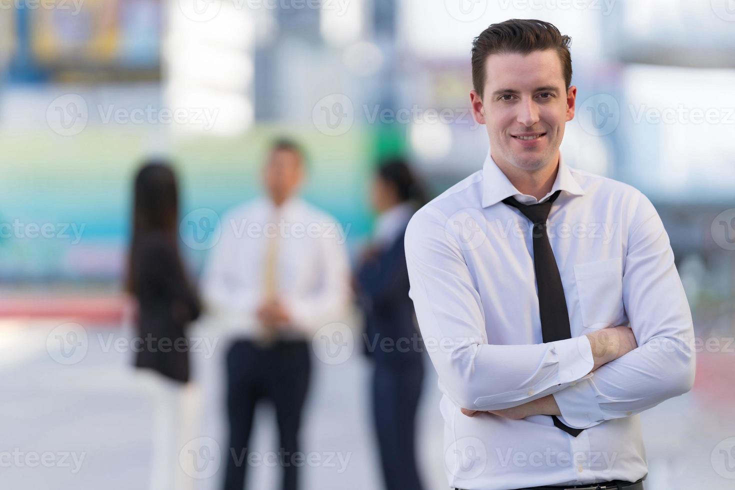 Portrait of successful businessman standing with arms crossed photo