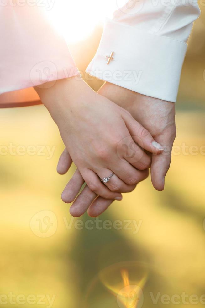 young couple holding hands on the arm ring. Close Up view photo