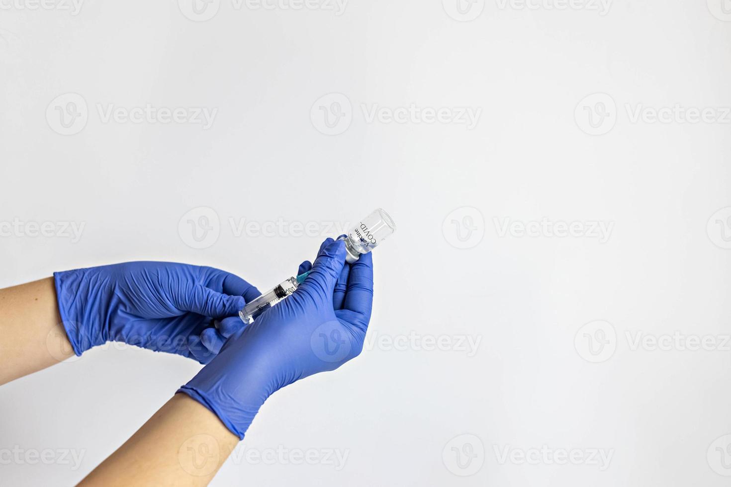 A medical worker in medical gloves draws a dose of coronavirus vaccine into a syringe. The concept of vaccination, immunization, prevention of people from Covid-19 photo