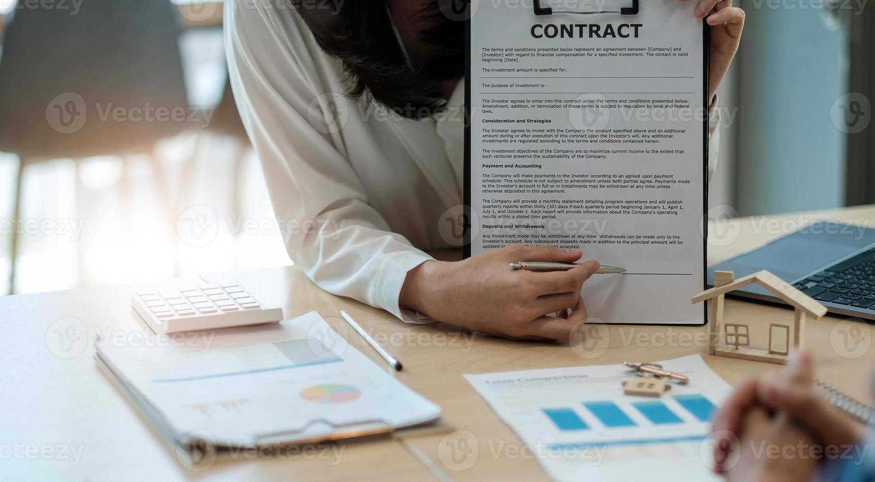 Sale purchase contract to buy a house, Real estate agent are presenting home loan and giving keys to customer after signing contract to buy house with approved property application form photo