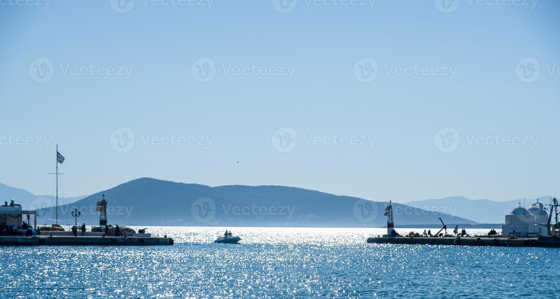 Entrada del puerto de la isla de Egina con la capilla de Agios Nicolás en vista foto