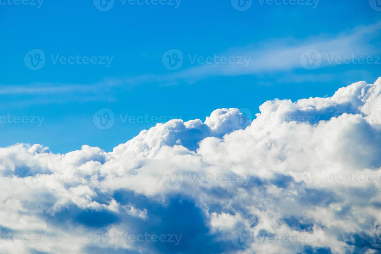 Fluffy white clouds on a blue sky. The view from the window of the plane. Background for design. photo
