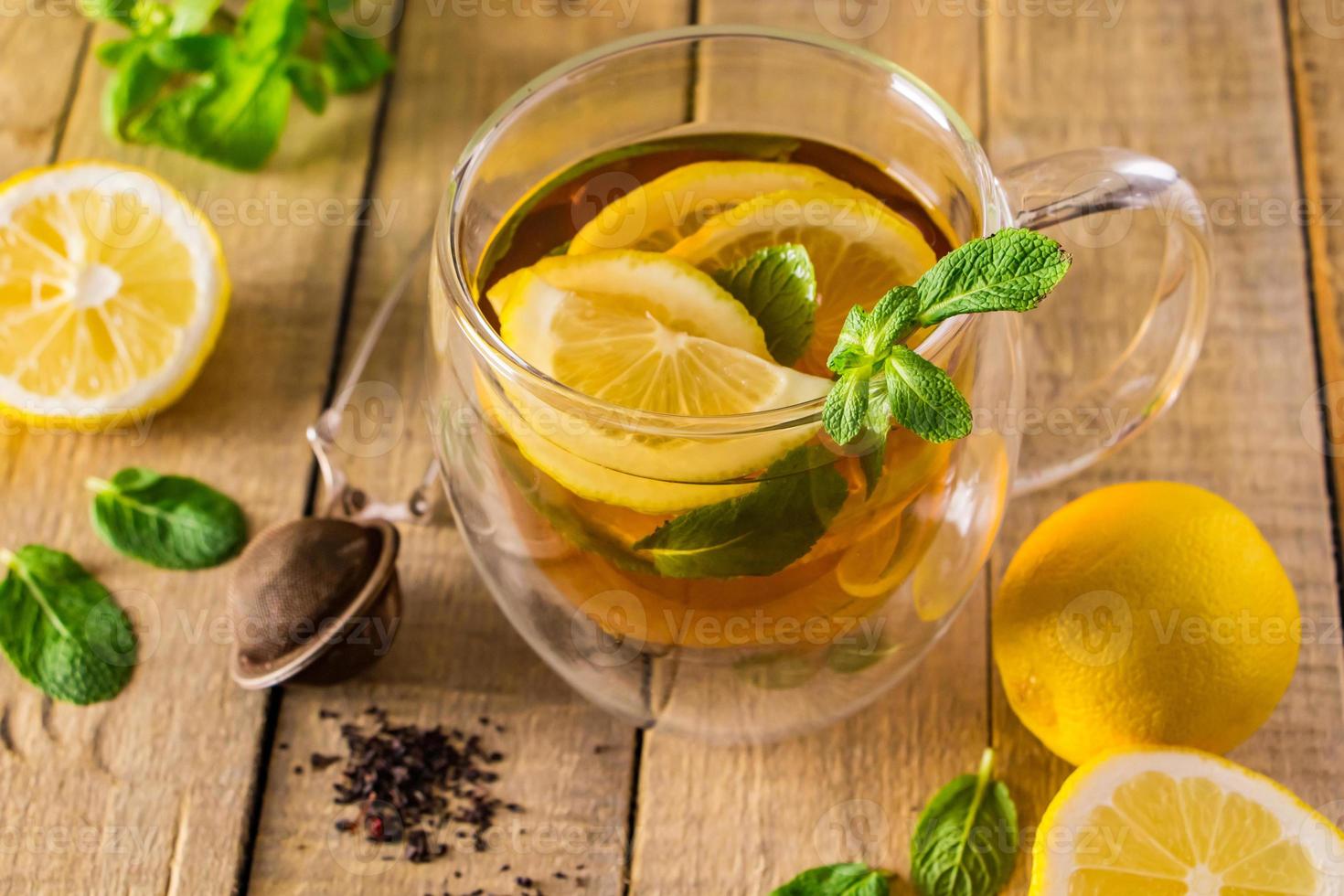té de hierbas con limón y menta sobre fondo de madera. deliciosa bebida para la relajación y terapia alternativa de enfermedades. foto