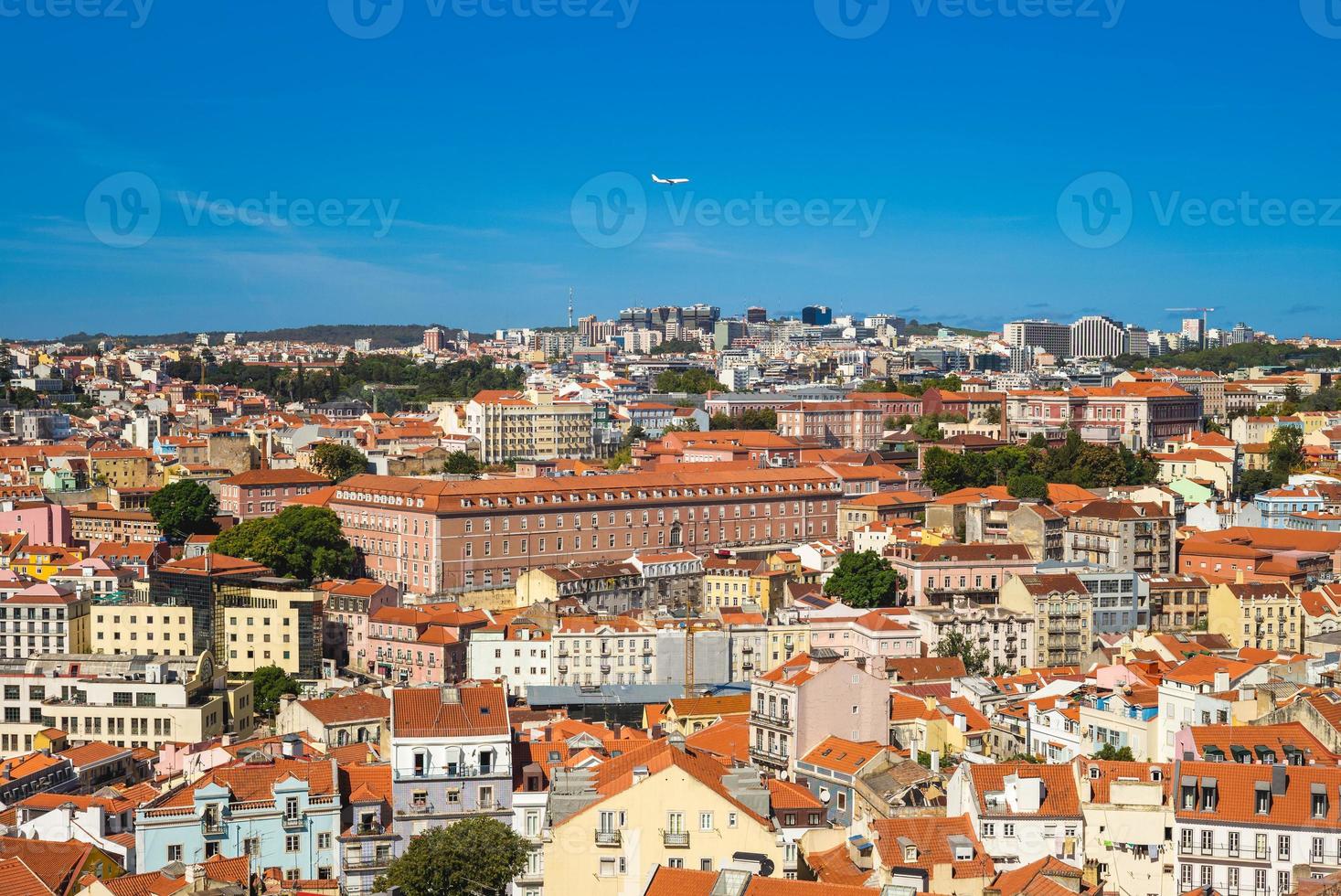 An airplane fly over lisbon, the capital city of portugal photo