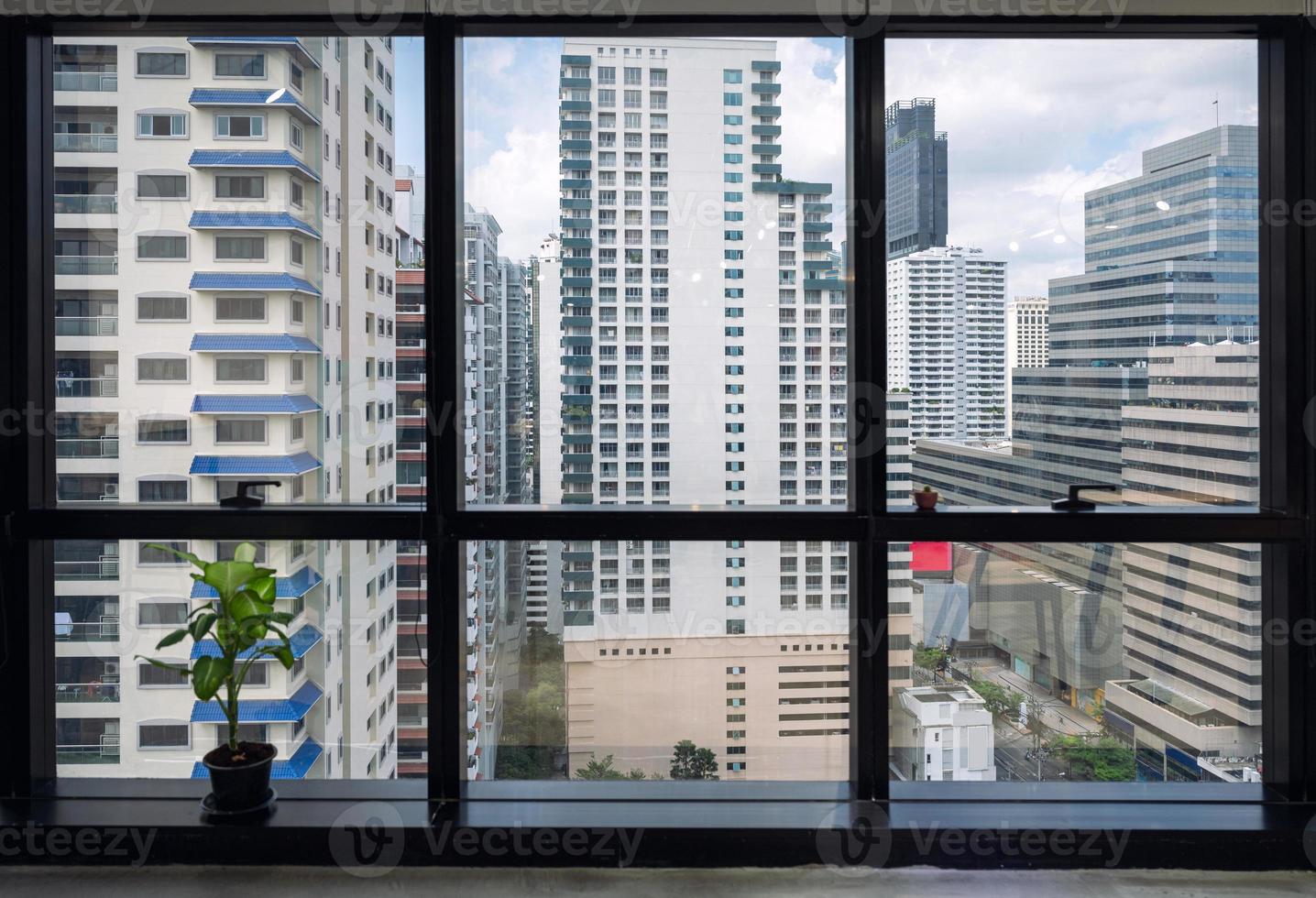 Interior de la oficina de la ventana y edificio abarrotado en el centro de la ciudad foto