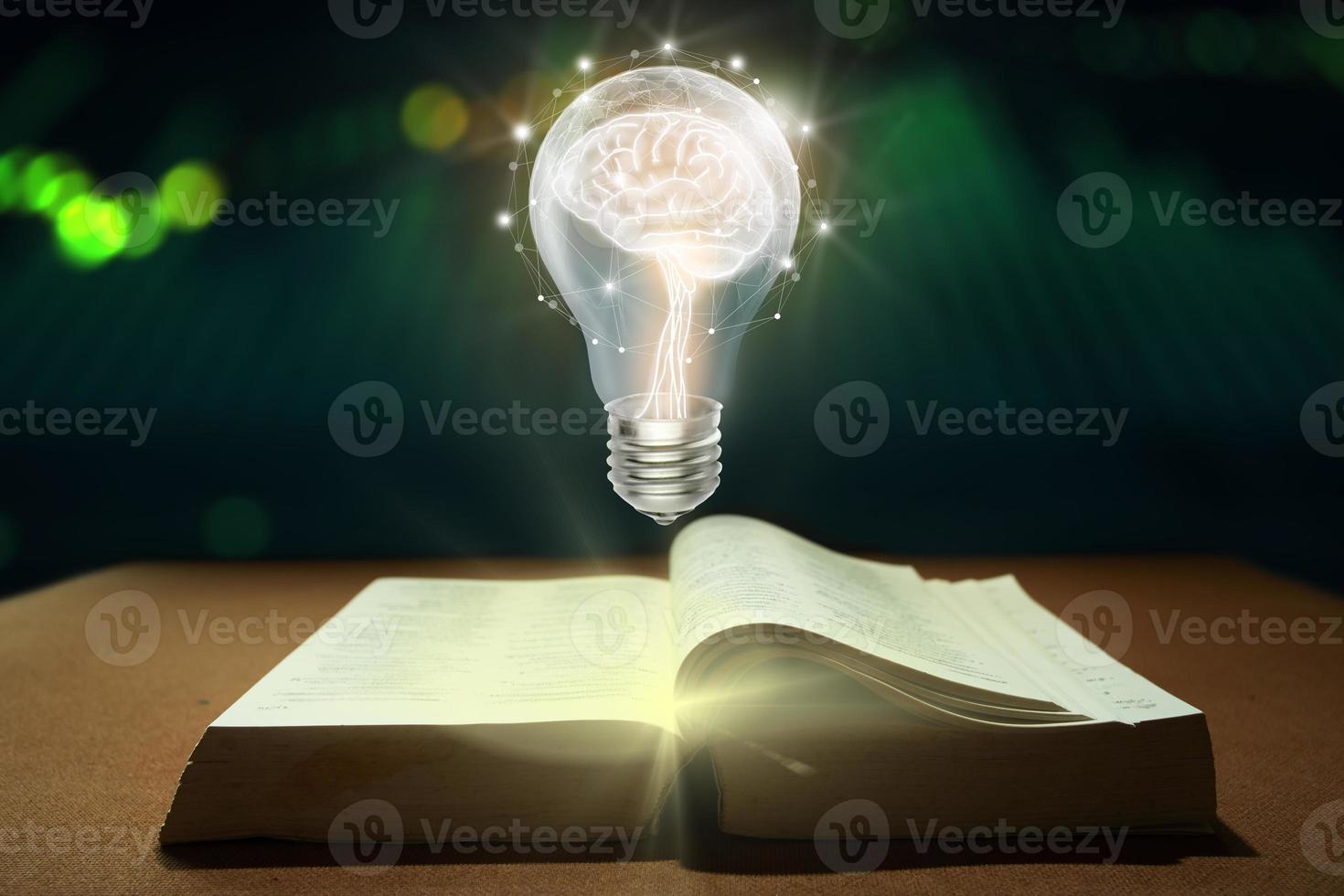 Brain inside the light bulb floating on the book photo