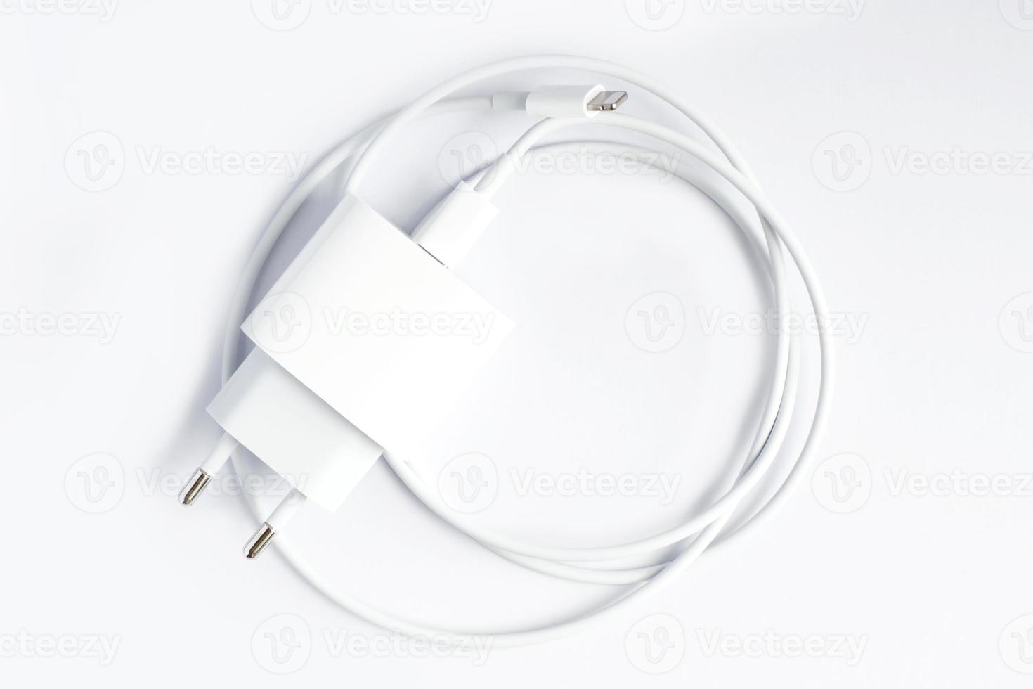 Top view of black phone AC charger and USB cable on white background photo