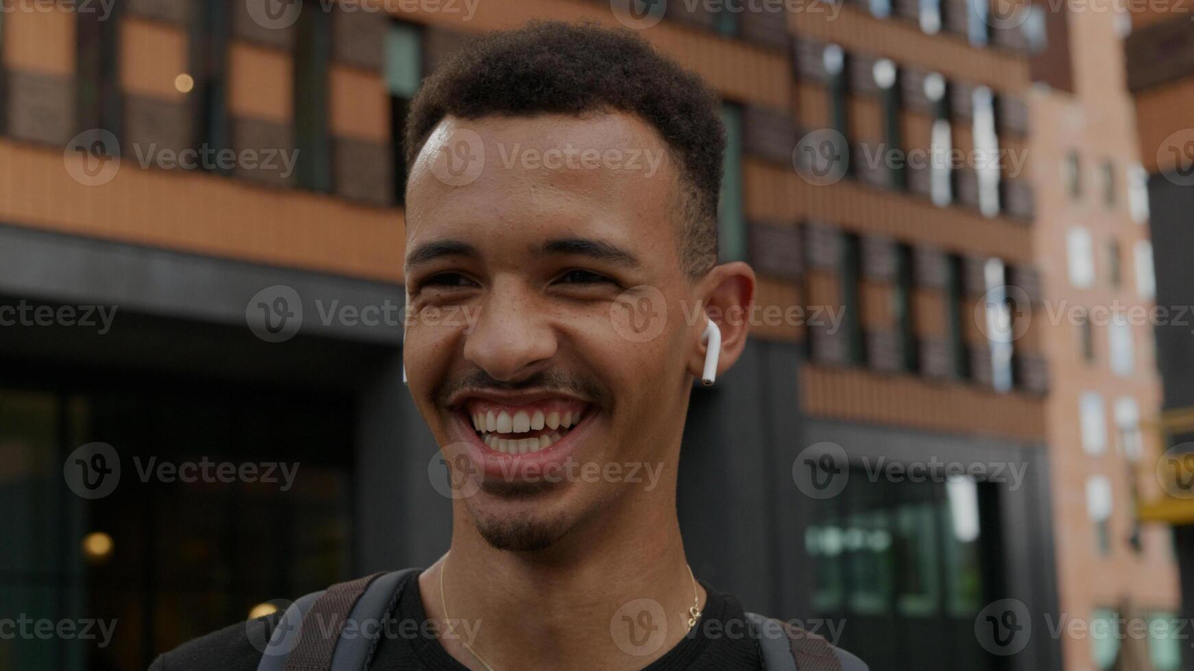 retrato, de, joven, llevando, inalámbrico, audífonos, reír foto