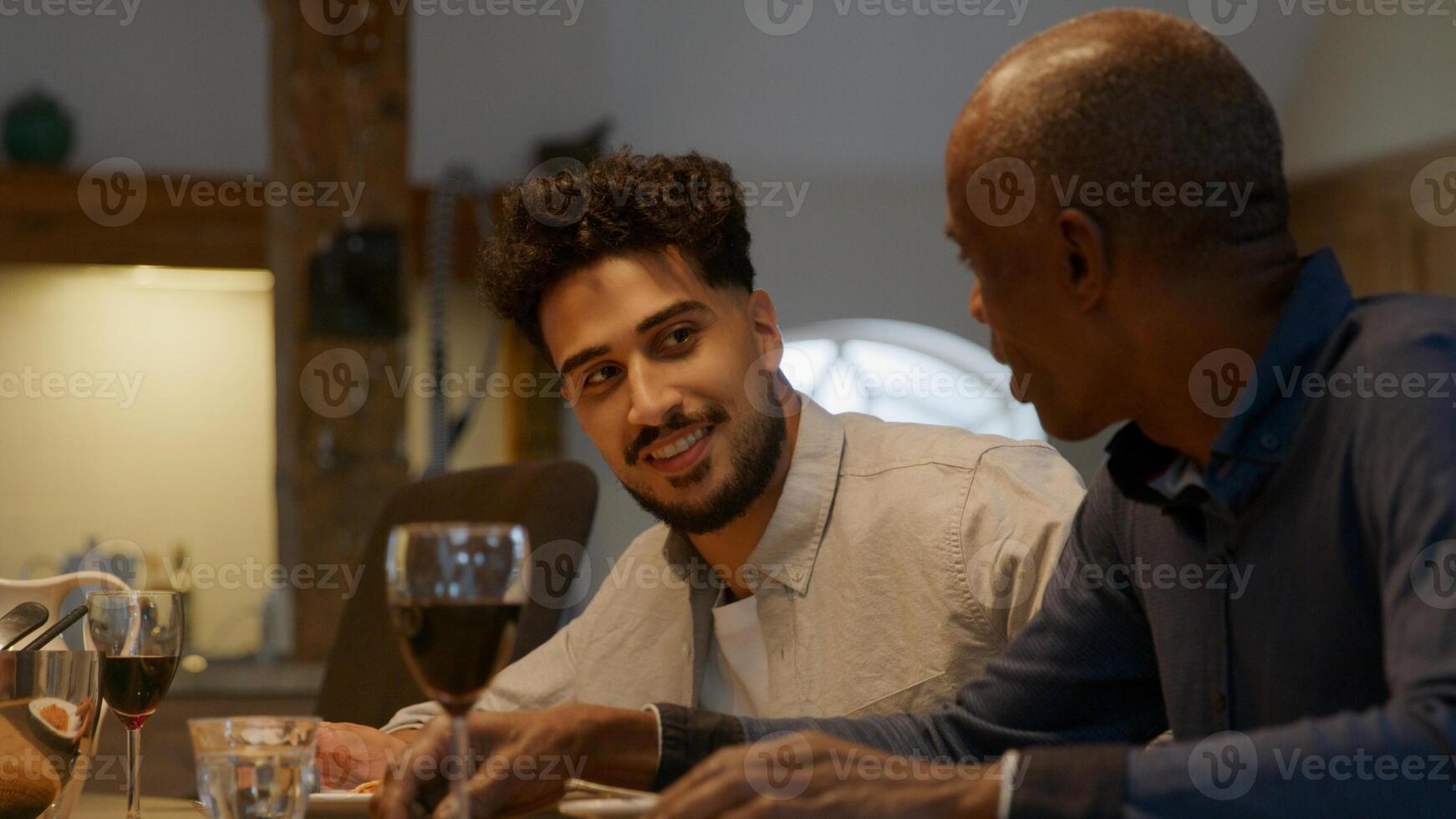 Two men sitting down at family dinner photo