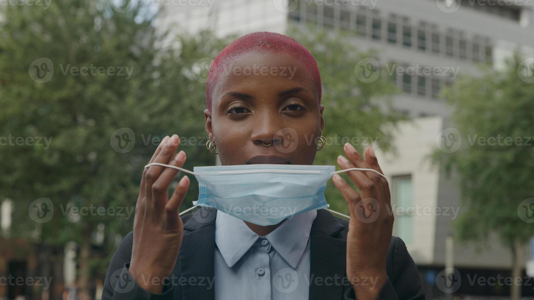 Portrait of young woman putting on protective face mask photo