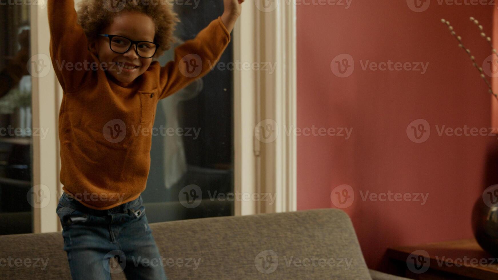 Excited young boy dancing with mother at home photo