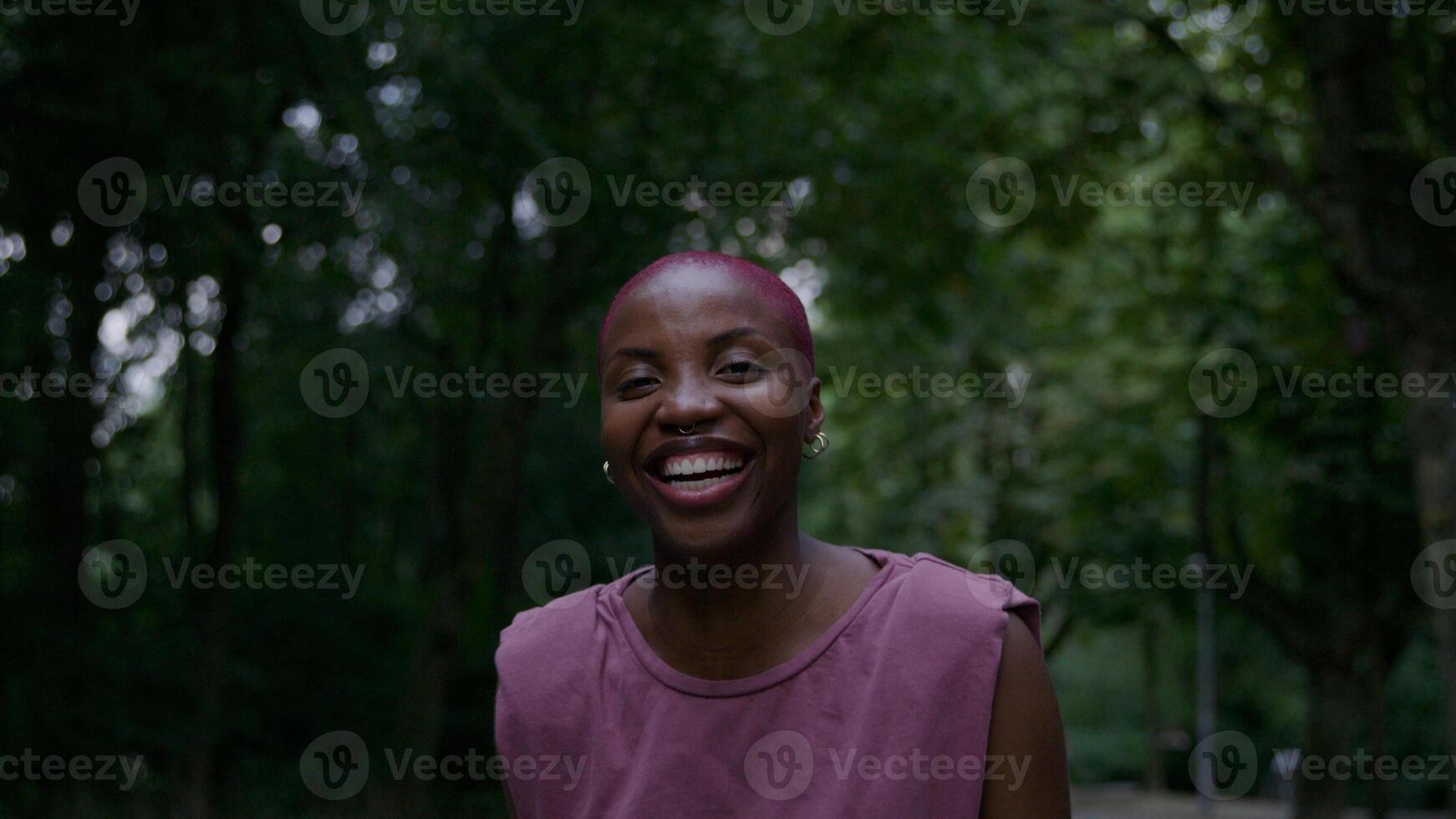 Portrait of young woman in park smiling and laughing photo