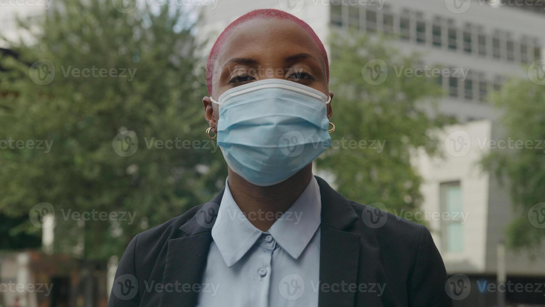 Portrait of young woman putting on protective face mask photo