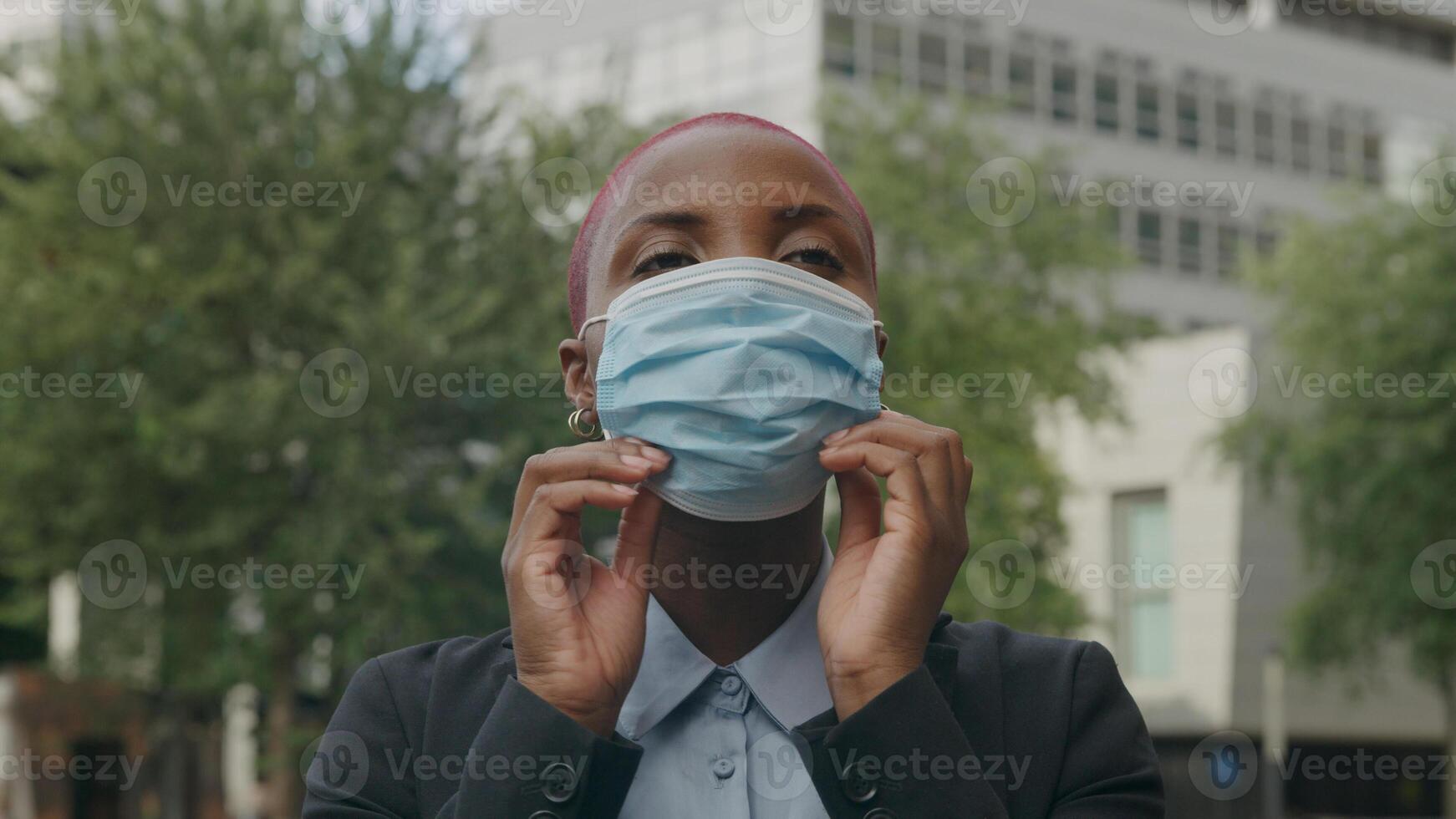 Portrait of young woman putting on protective face mask photo