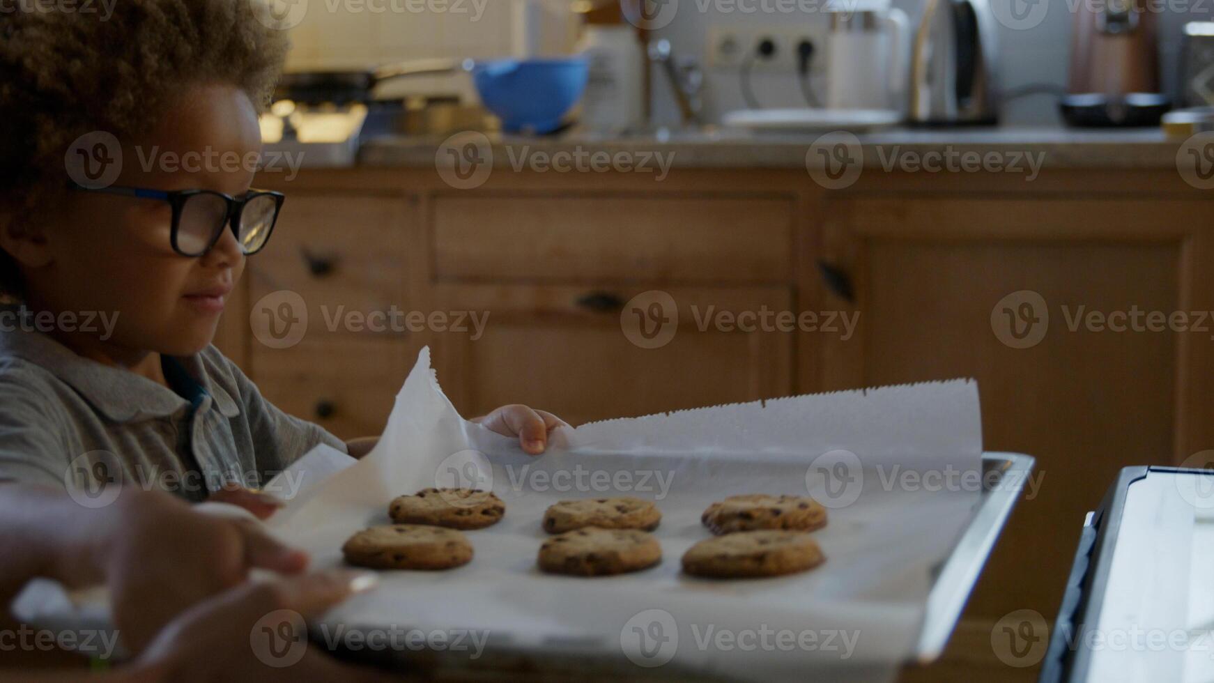 Mother and son putting homemade cookies in oven photo