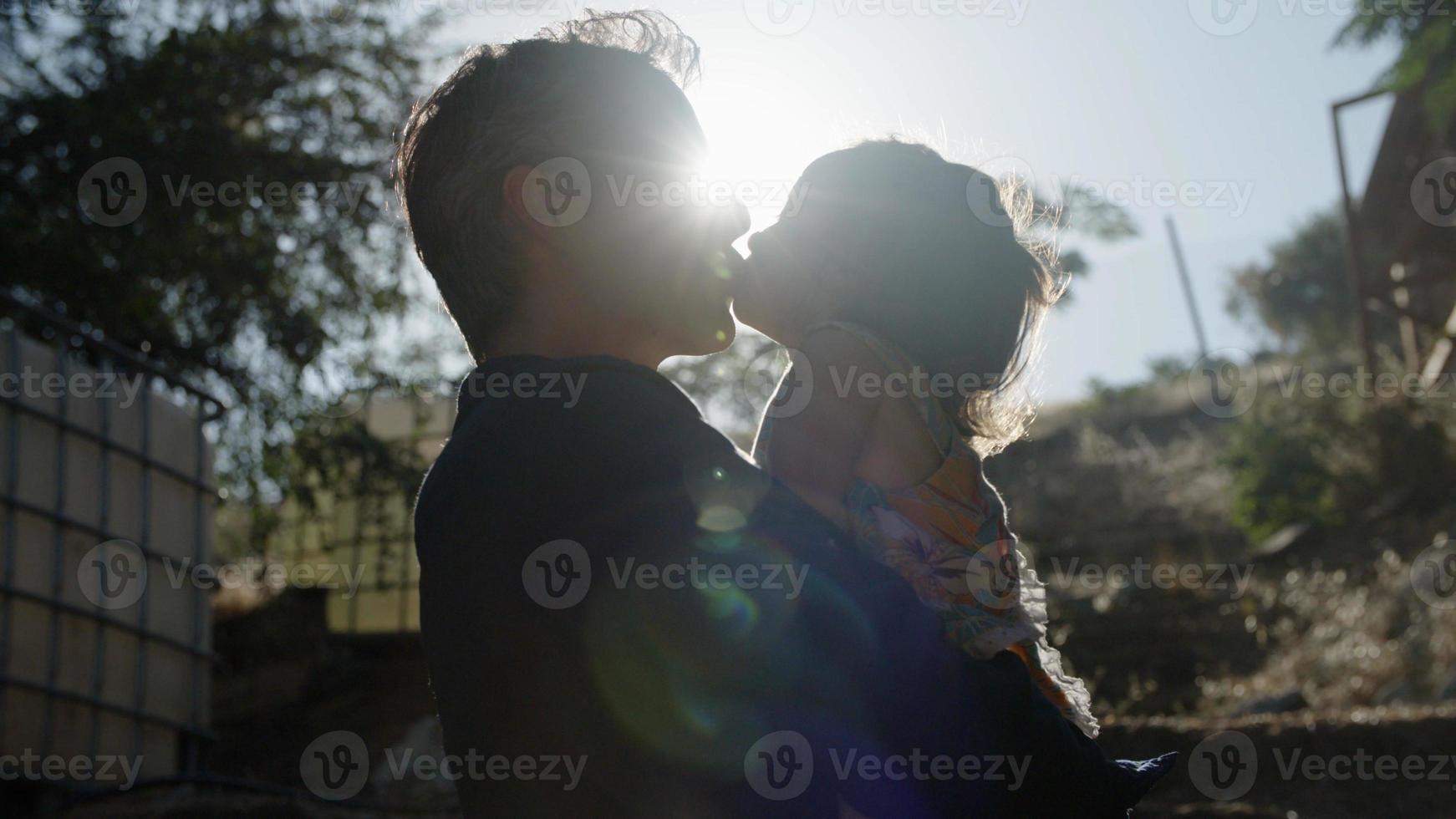 Portrait of father holding daughter in sunlight photo
