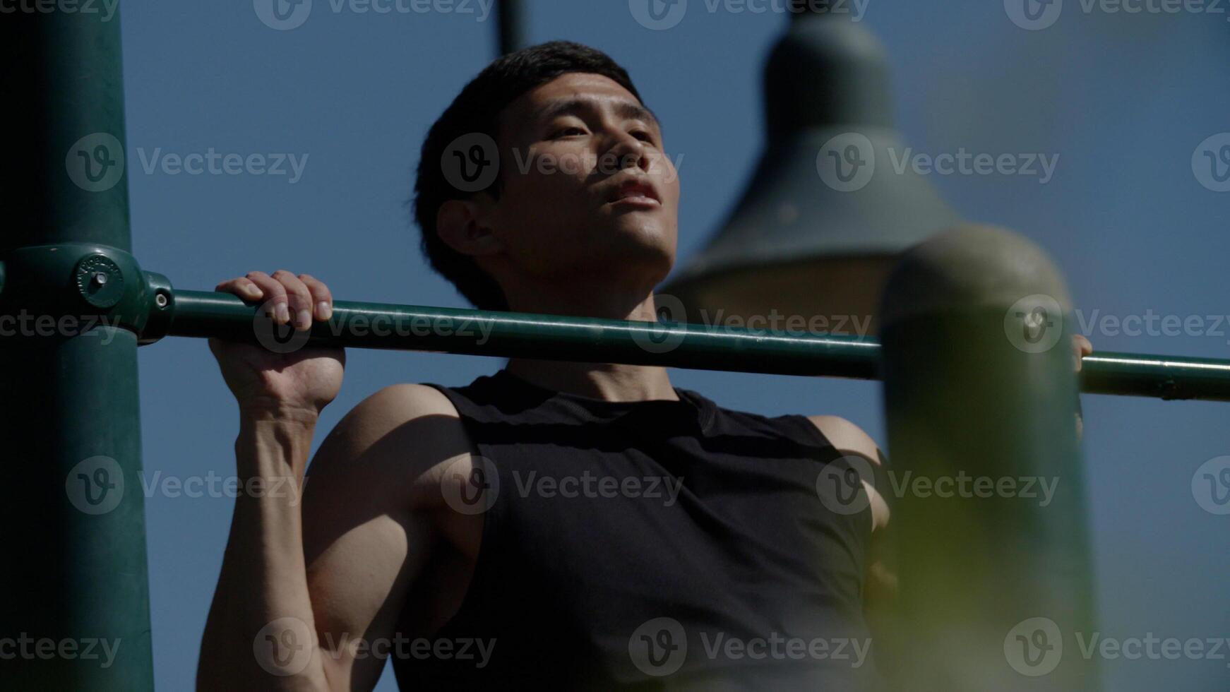 Portrait of mid adult man doing pull ups photo