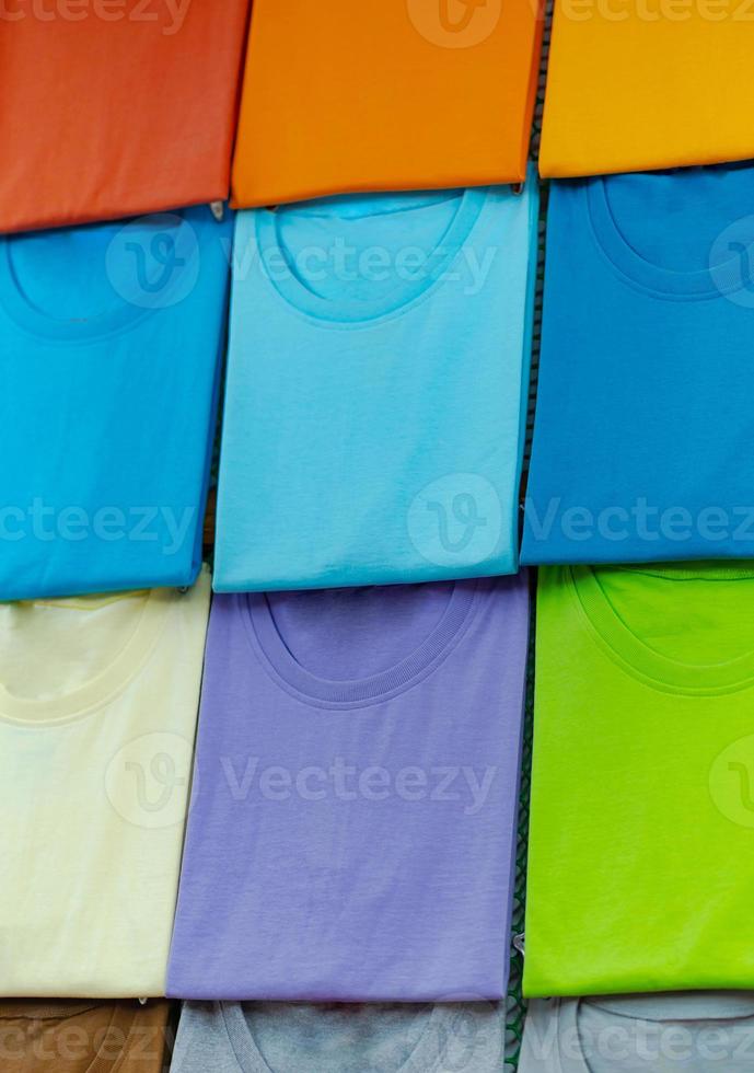 Cerca de coloridas camisetas en perchas foto