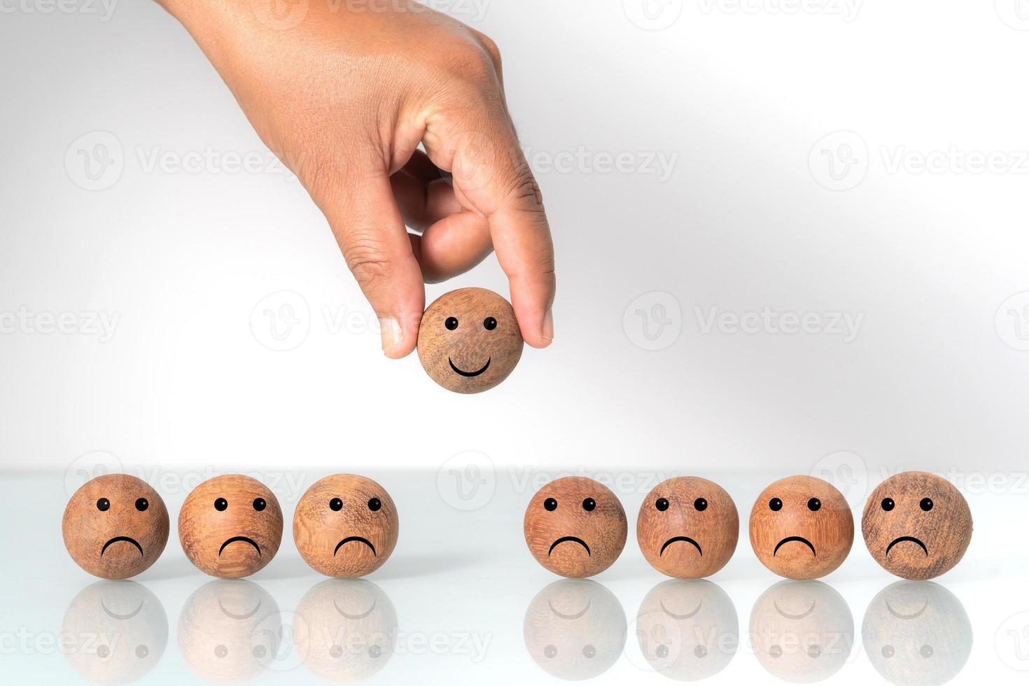 Hand putting on a smiling wooden ball, Concept of recruiting photo