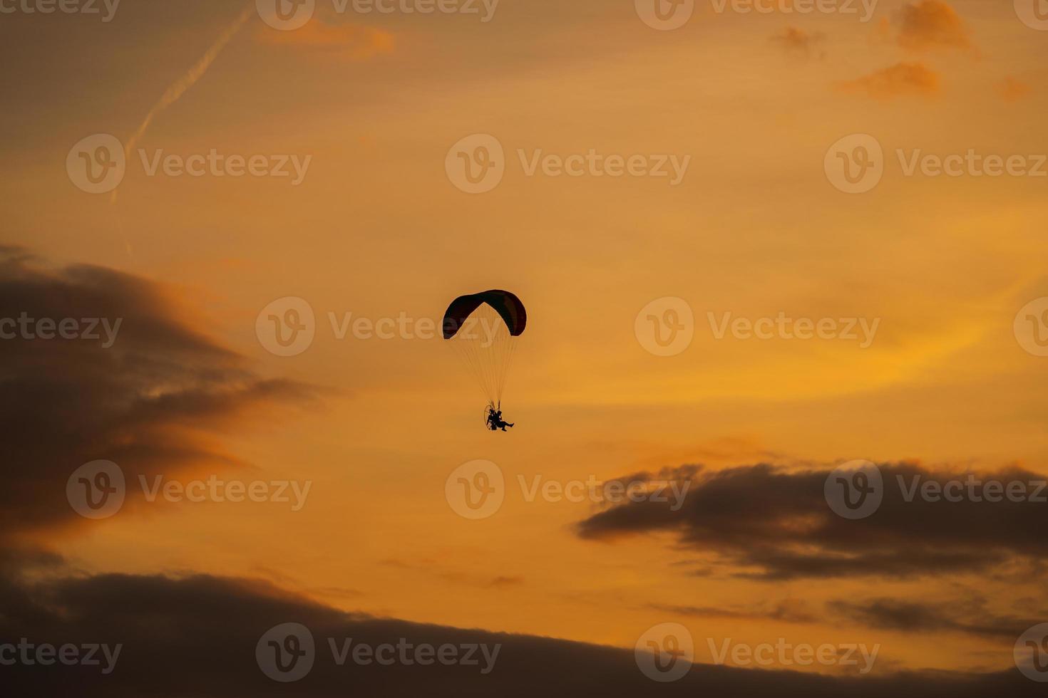 The silhouette of the paramotor at sunset photo