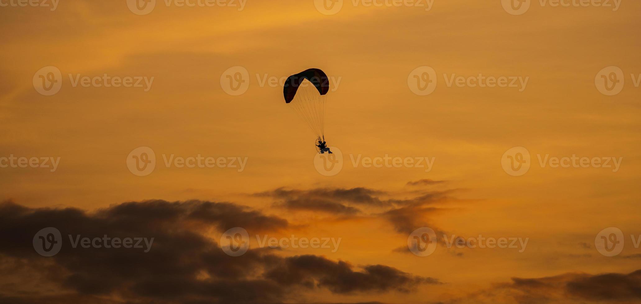 la silueta del paramotor al atardecer foto