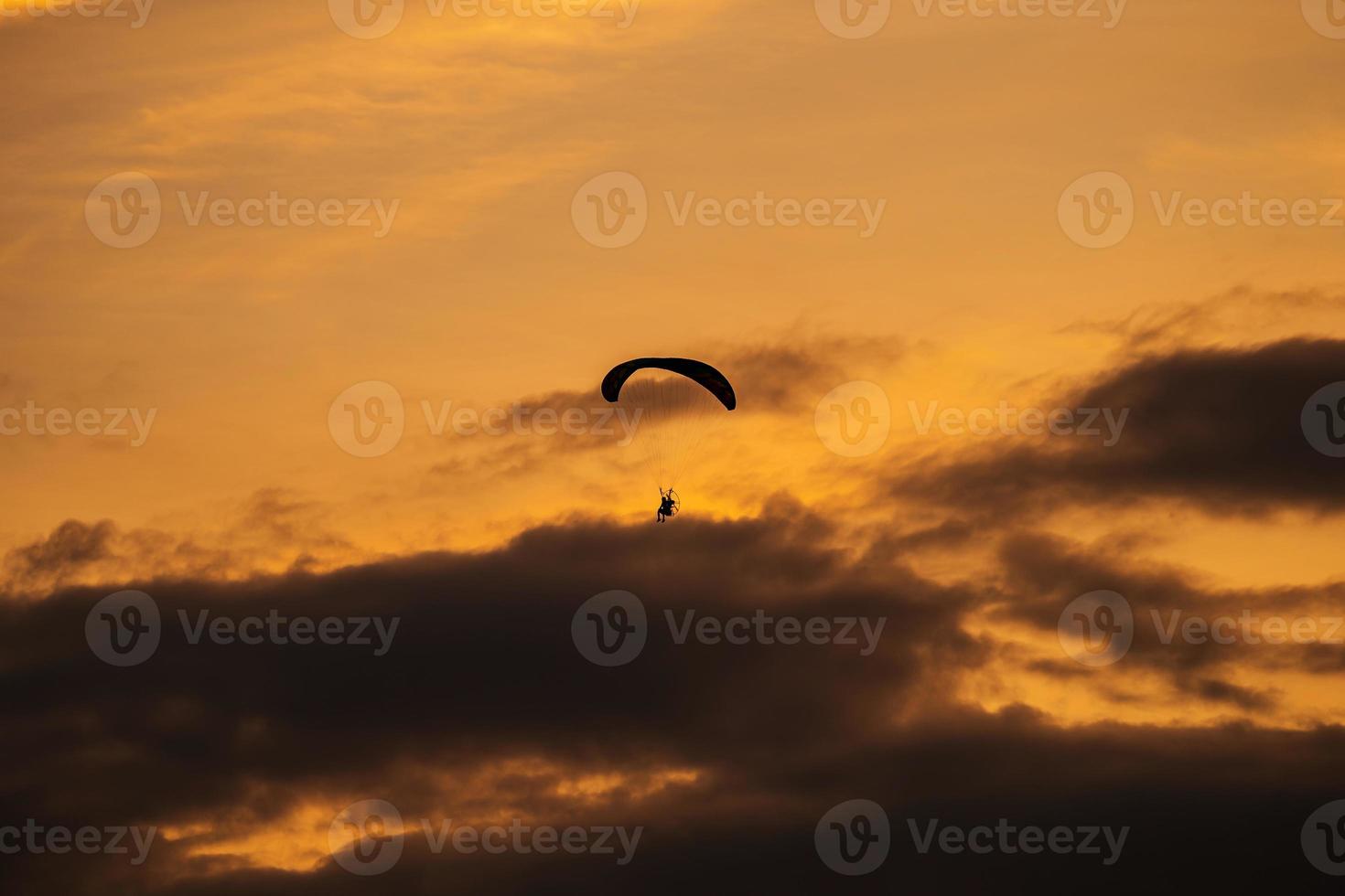 la silueta del paramotor al atardecer foto