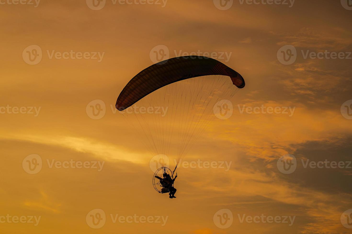 The silhouette of the paramotor at sunset photo