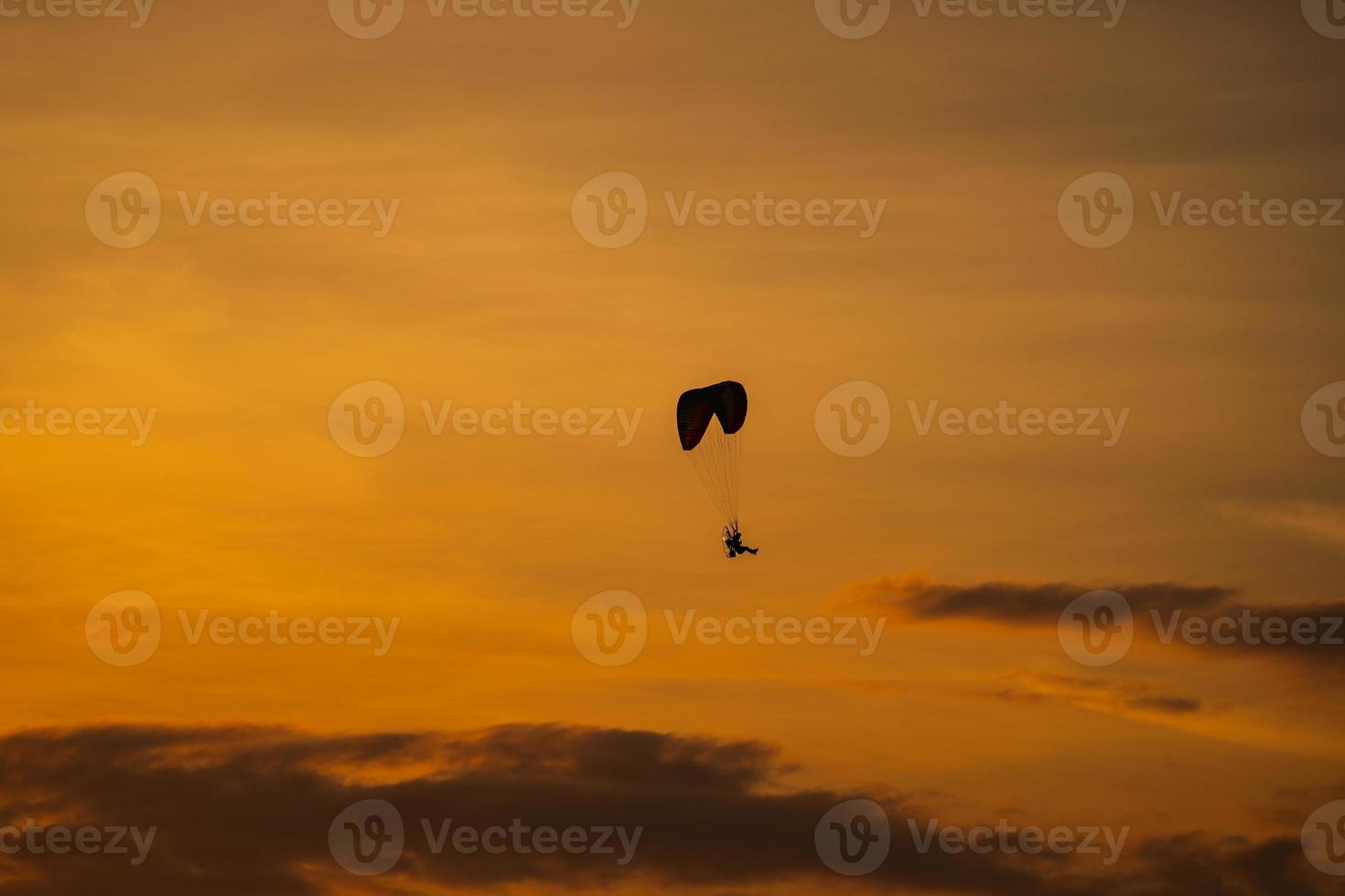 The silhouette of the paramotor at sunset photo