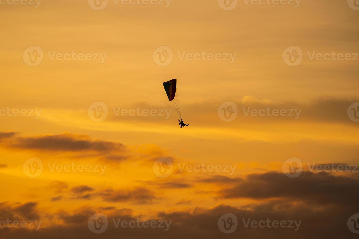 The silhouette of the paramotor at sunset photo