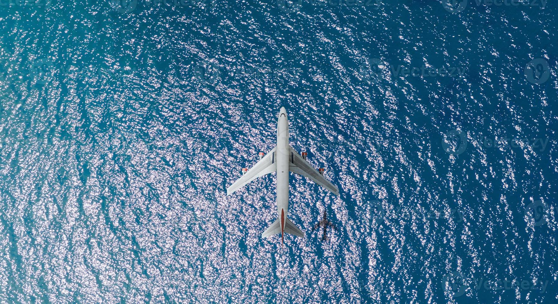 Aerial top view of Airplane flies over a sea, view from above photo