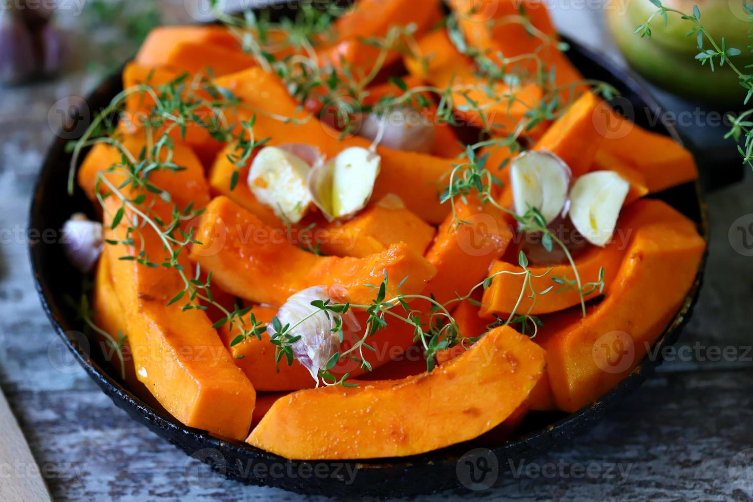 Pieces of pumpkin in a skillet before baking photo