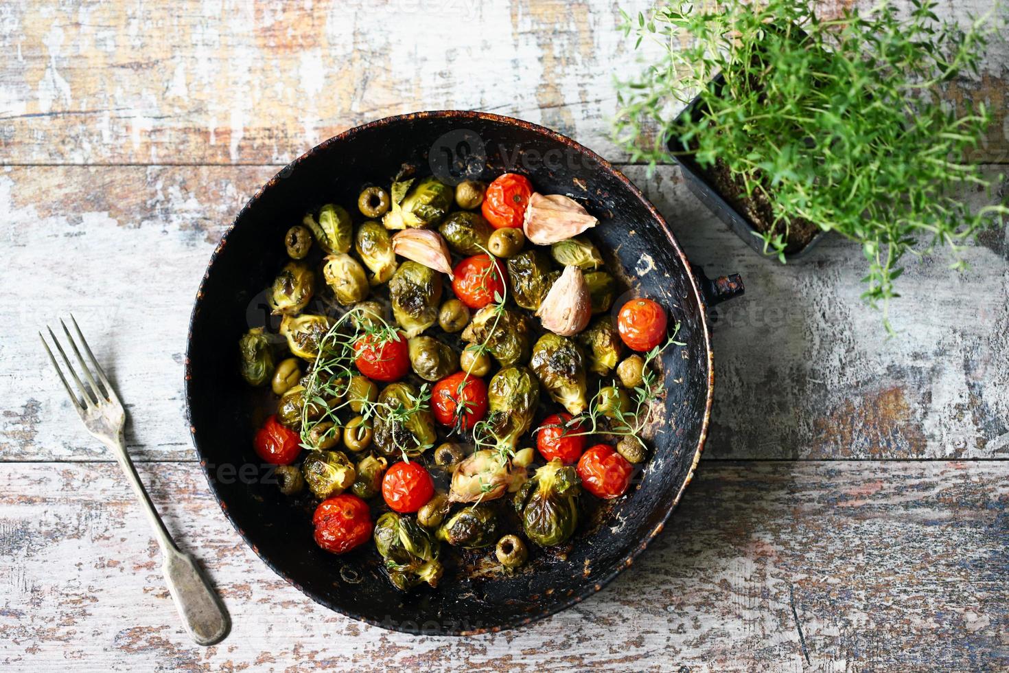 Brussels sprouts with vegetables and herbs in a pan photo