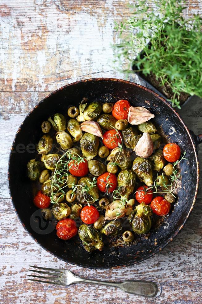 Brussels sprouts with vegetables and herbs in a pan photo