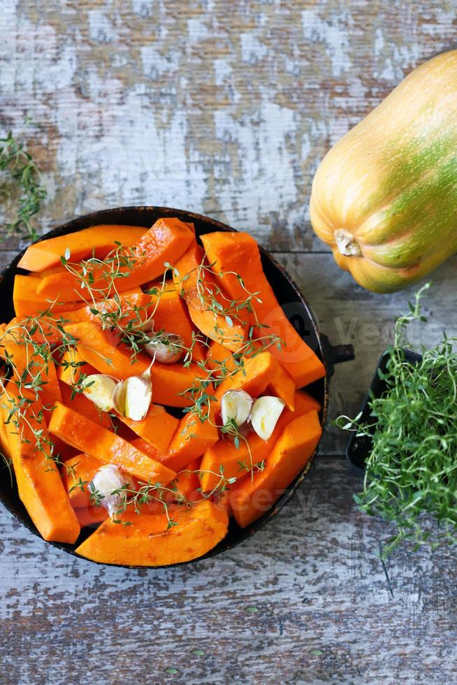 Pieces of pumpkin in a skillet before baking photo