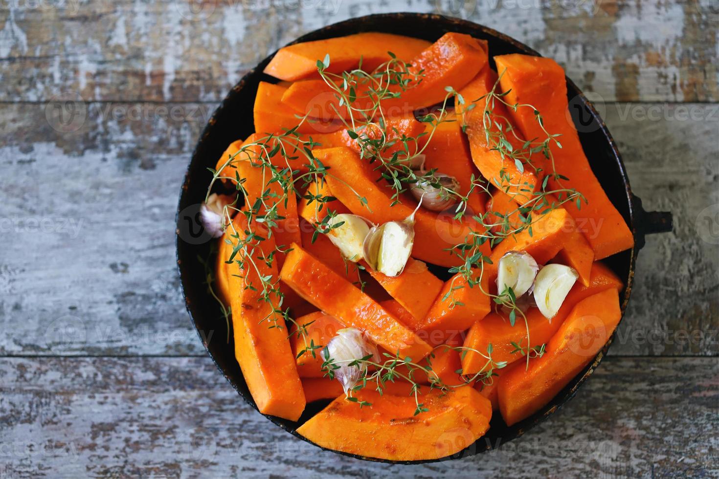 Pieces of pumpkin in a skillet before baking photo