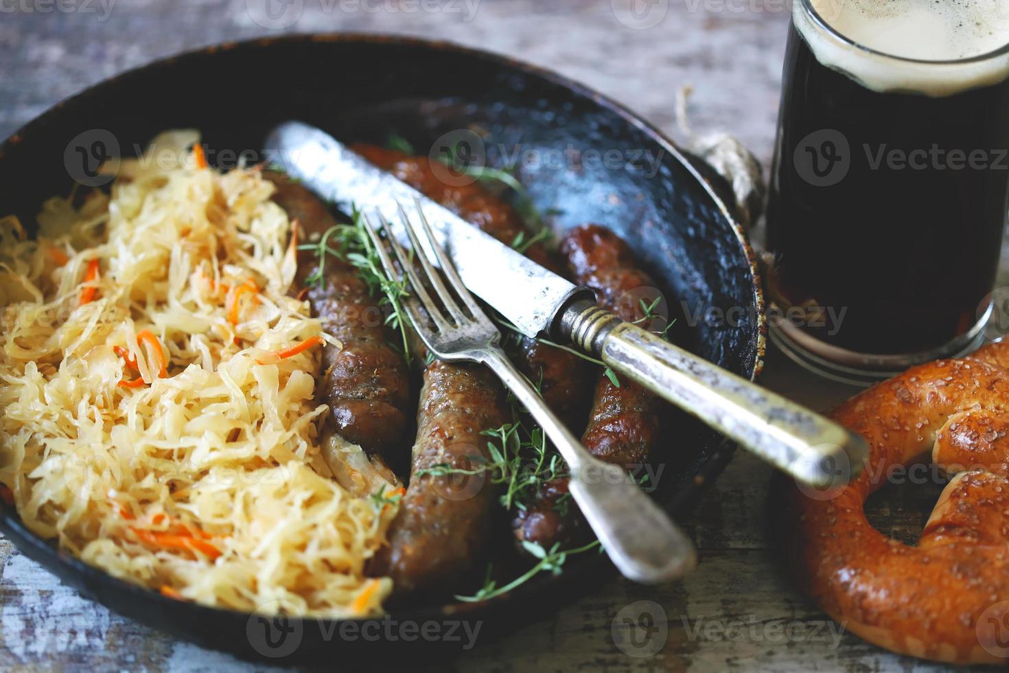 Salchichas bávaras en una sartén con chucrut guisado comida oktoberfest foto