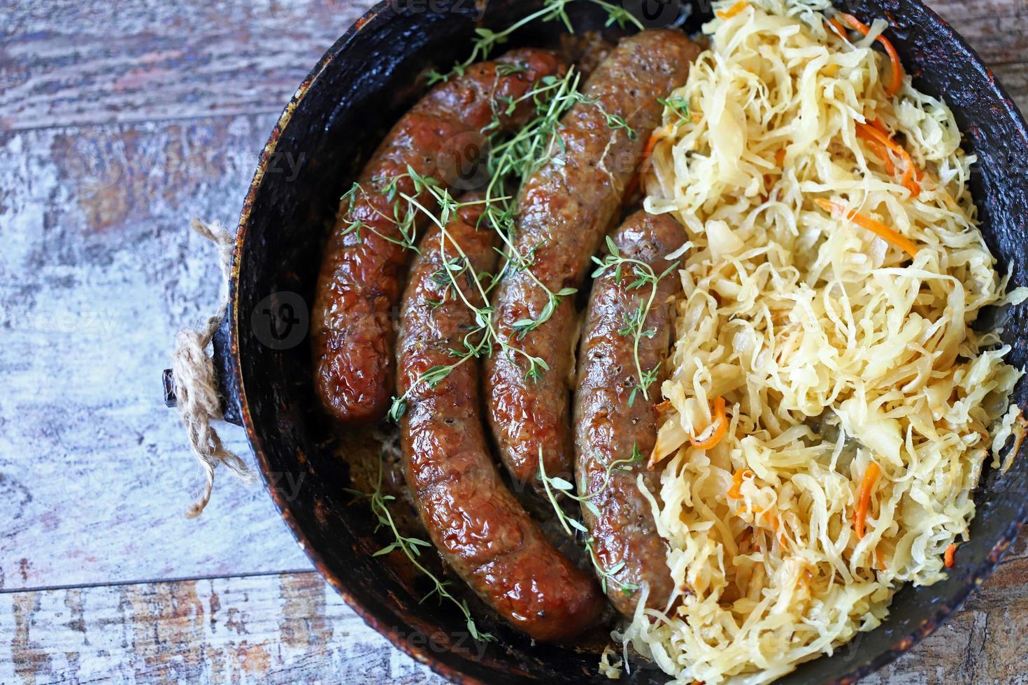 Salchichas bávaras en una sartén con chucrut guisado comida oktoberfest foto